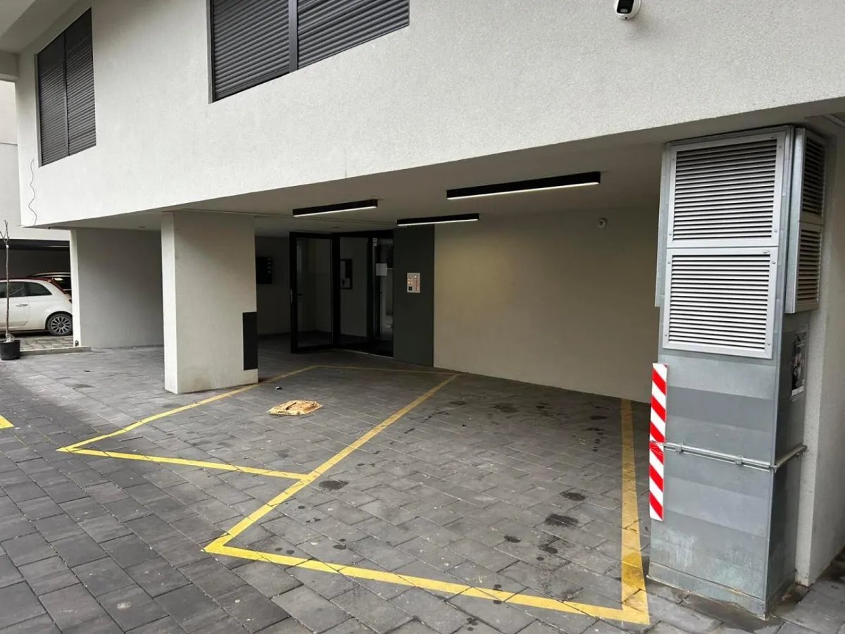 Obeleženo parking mesto u dvorištu zgrade sa apartmanima
